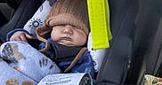 Kaiser joined the competition — help win amazing prizes! baby, blanket, car_seat, child, child_seat, cozy, cute, face, hat, headwear, indoor, infant, nap, person, receipt, resting, seatbelt, sleeping, soft_toys, warm_clothing