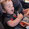 baby, car_seat, child, plush_toy, hand, car_interior, seatbelt, clothing, smile, joy, infant, cute, portrait, black_fabric, window, daylight, seat, person, toddler, toy