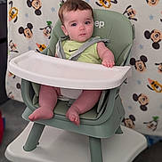 Paxxton joined the competition — help win amazing prizes! baby, high_chair, child, infant, green, nike, shirt, face, legs, feet, expression, blanket, mickey_mouse, disney, pattern, indoor, seat, strap, person, curious