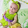 baby, child, green_dress, headband, fairy_wings, plush_doll, soft_blanket, purple_flowers, cute, portrait, indoors, smile, happy, toy, costume, close_up, infant, lying_down, face, person