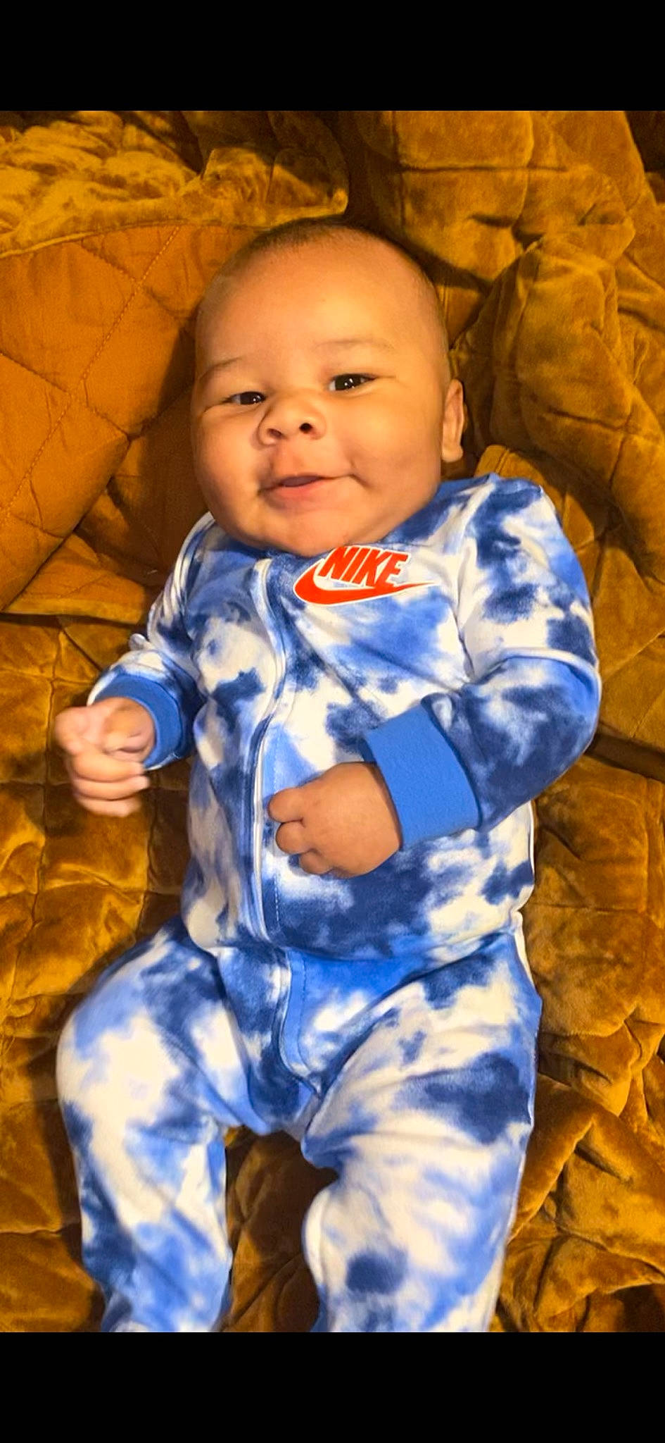 Carter is registered to the contest to win money with this photo: arm, baby_toddler_clothing, cheek, chin, eye, face, facial_expression, hair, hairstyle, head, iris, nose, orange, organ, person, photograph, skin, sleeve, smile, standing