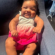 Alaniela is registered to the contest to win money with this photo: baby, child, smiling, dress, pink, white, armchair, happy, infant, sitting, cute, indoors, furniture, skin, legs, person, portrait, sunlight, cozy, comfortable