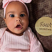 Carlarae joined the competition — help win amazing prizes! baby, infant, child, pink_clothing, headband, surprised_expression, face, eyes, mouth_open, blanket, wooden_sign, four_months, lying_down, indoors, cute, portrait, soft_texture, young, skin, person