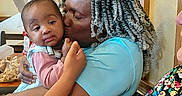 Melody joined the competition — help win amazing prizes! baby, woman, kiss, indoor, hair, braids, child, person, love, affection, family, holding, clothing, table, chair, window, curtains, skin, face, expression