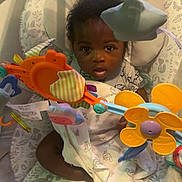 Nolan joined the competition — help win amazing prizes! baby, infant, child, baby_seat, toy, colorful_toy, face, eyes, blanket, clothing, foot, hand, indoor, baby_toy, cute, portrait, young_child, seat, playtime, curious