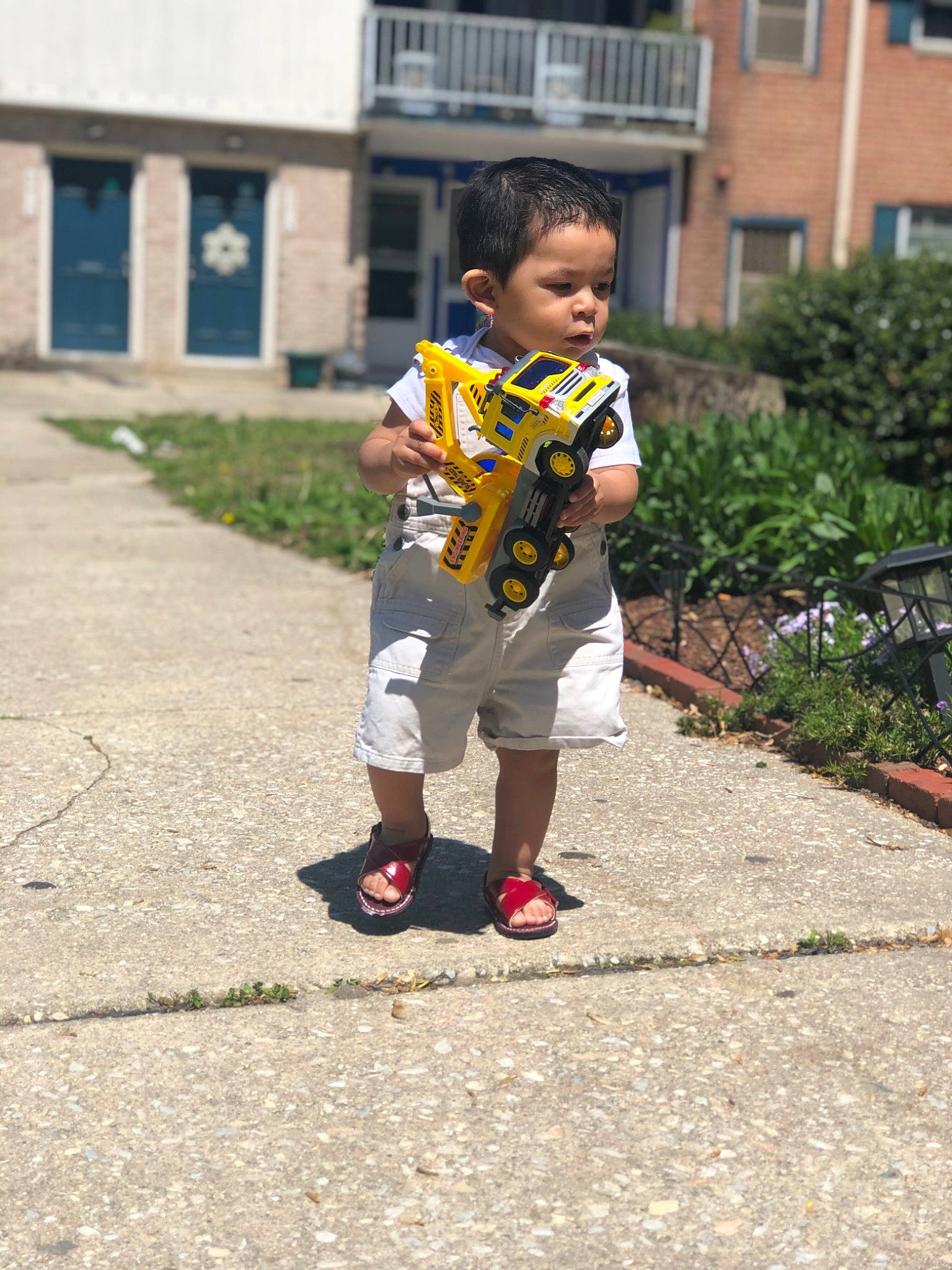 Leonel is registered to the contest to win money with this photo: baby_toddler_clothing, bermuda_shorts, child, person, play, sandal, slipper, sock, toddler, walking_shoe, window, yard