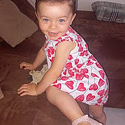 Anna participe au concours pour gagner de l'argent avec cette photo : toddler, child, smiling, blue_eyes, dress, hearts_pattern, pink_sandals, hair, couch, plush_toy, pillow, blanket, indoor, floor_tiles, happy, climbing, person, cute, young_child, playful