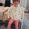 barefoot, bed, bedroom, blanket, cardigan, carpet, carpeted_floor, chair, child, computer, curtains, desk, face, happy, indoors, person, pink_pants, smiling, toddler, toy