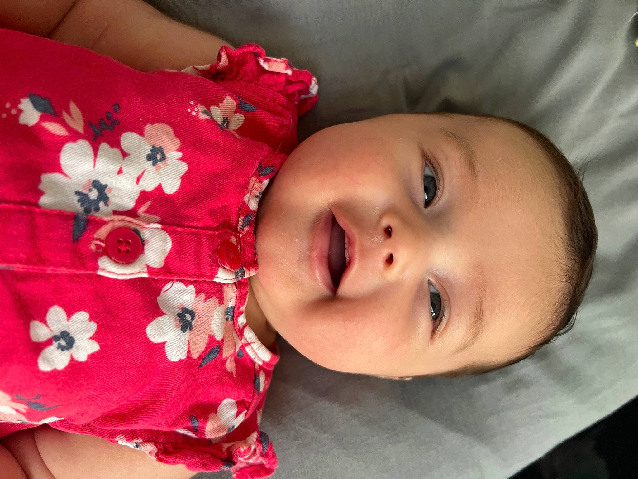 Sadie is registered to the contest to win money with this photo: arm, baby, baby_toddler_clothing, cheek, child, chin, dress, eyelash, hand, happy, human_body, lip, nose, person, pink, plant, rose, skin, sleeve, smile