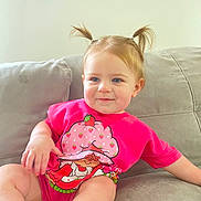 Amelia joined the competition — help win amazing prizes! blue_eyes, cartoon_print, casual, child, couch, cute, happy, home, indoor, light, pigtails, pink_shirt, portrait, relaxed, seated, short_sleeves, skin, smiling, toddler, young_child