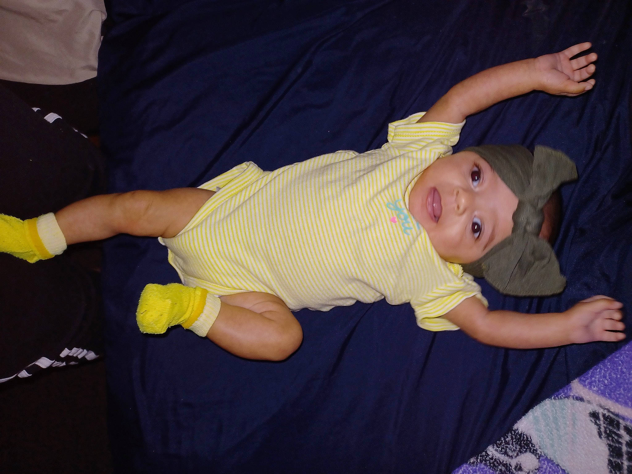 Brielle is registered to the contest to win money with this photo: arm, baby, baby_toddler_clothing, child, comfort, elbow, event, finger, fun, gesture, happy, hat, headwear, lap, muscle, person, sleeve, smile, t_shirt, thigh