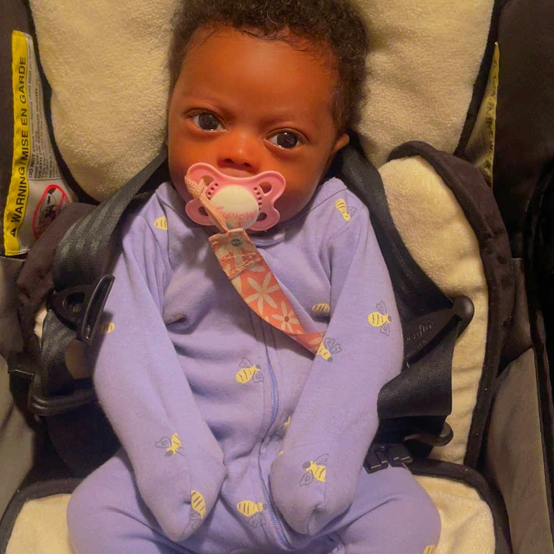 Indiyah is registered to the contest to win money with this photo: baby, blanket, car, car_interior, carseat, clothing, cushion, face, footwear, furniture, hat, head, homedecor, person, photography, portrait, shoe, sitting, transportation, vehicle