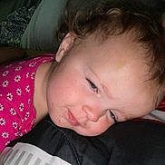 Brooklynn is registered to the contest to win money with this photo: toddler, child, sleepy, face, pink_shirt, floral_pattern, blanket, striped, close_up, indoors, curly_hair, resting, cozy, person, young_child, expression, bedroom, casual, portrait, smudged_face
