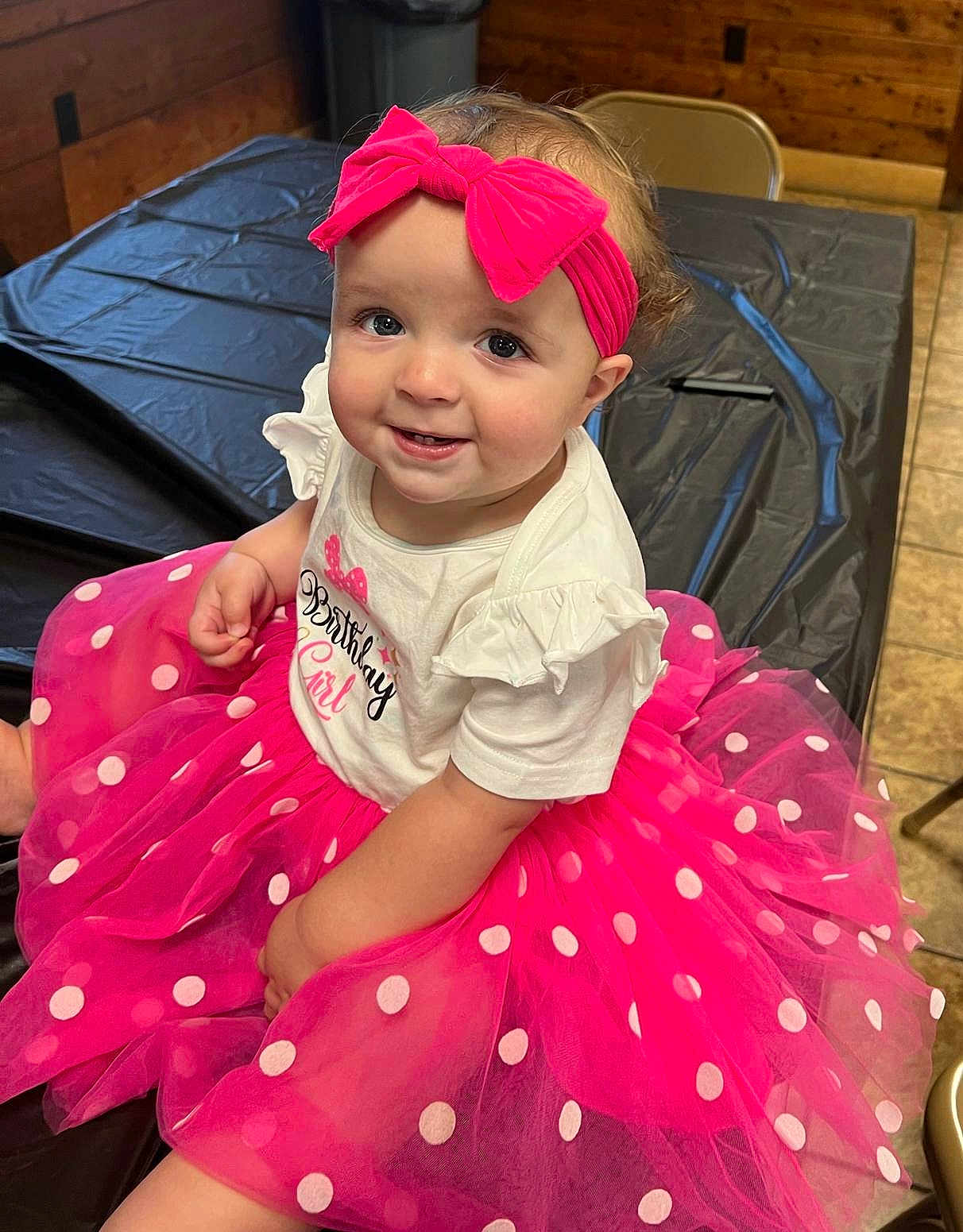Brooklynn is registered to the contest to win money with this photo: baby, child, birthday, pink, tutu, headband, polka_dot, smile, happy, indoor, table, clothing, person, cute, celebration, sitting, face, dressed_up, toddler, fun