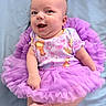 Sienna joined the competition — help win amazing prizes! baby, child, infant, smiling, happy, portrait, tutu, purple, dress, butterfly, floral, sitting, indoor, blanket, blue_background, barefoot, arms, legs, face, photography