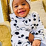 toddler, child, smiling, hat, onesie, panda_pattern, socks, armchair, yellow_curtain, indoor, cozy, happy, portrait, baby, furniture, warm_light, cute, seated, casual_clothing, home