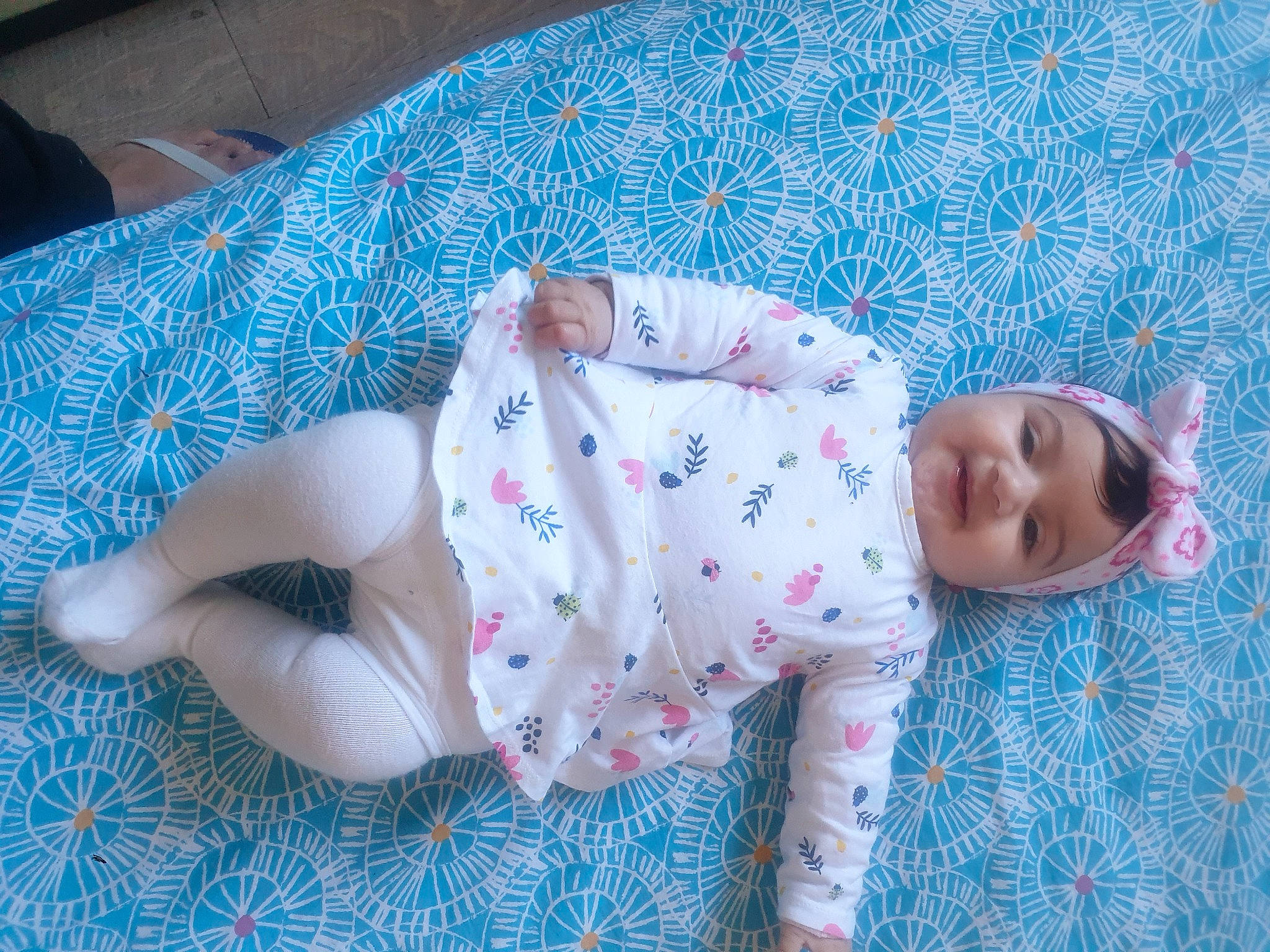 Mila a rejoint le concours — aidez-le/la à gagner de superbes lots ! baby, baby_toddler_clothing, child, comfort, electric_blue, flooring, foot, grass, headgear, headwear, human_body, human_leg, joy, linens, pattern, person, sitting, skin, sleeve, sock