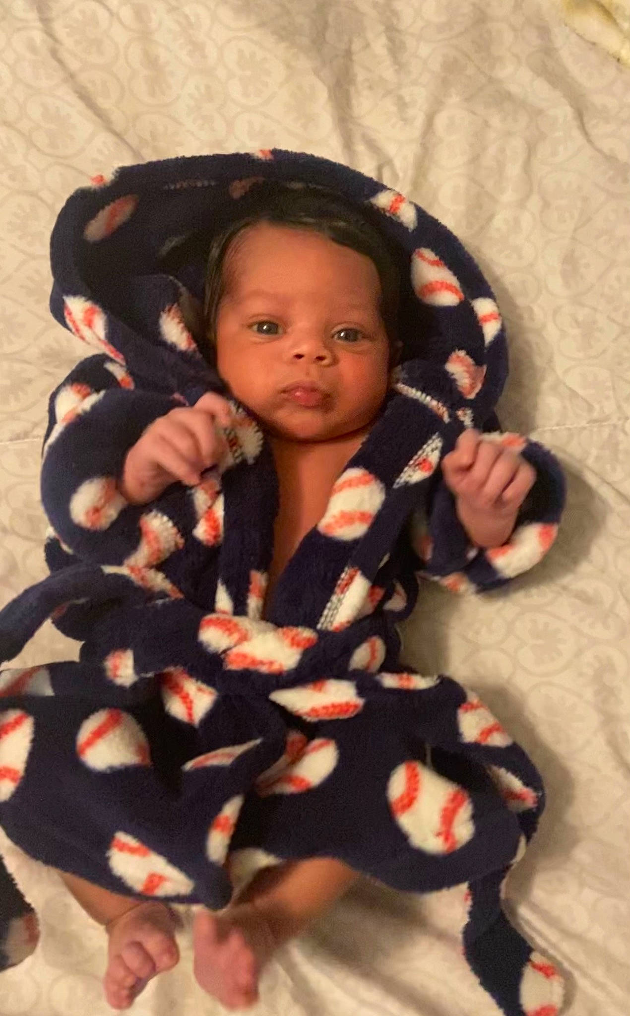 Ace is registered to the contest to win money with this photo: arm, baby, baby_products, baby_toddler_clothing, black_hair, cheek, child, eye, fashion_accessory, finger, fun, gesture, happy, lip, neck, pattern, person, skin, sleeve, thumb