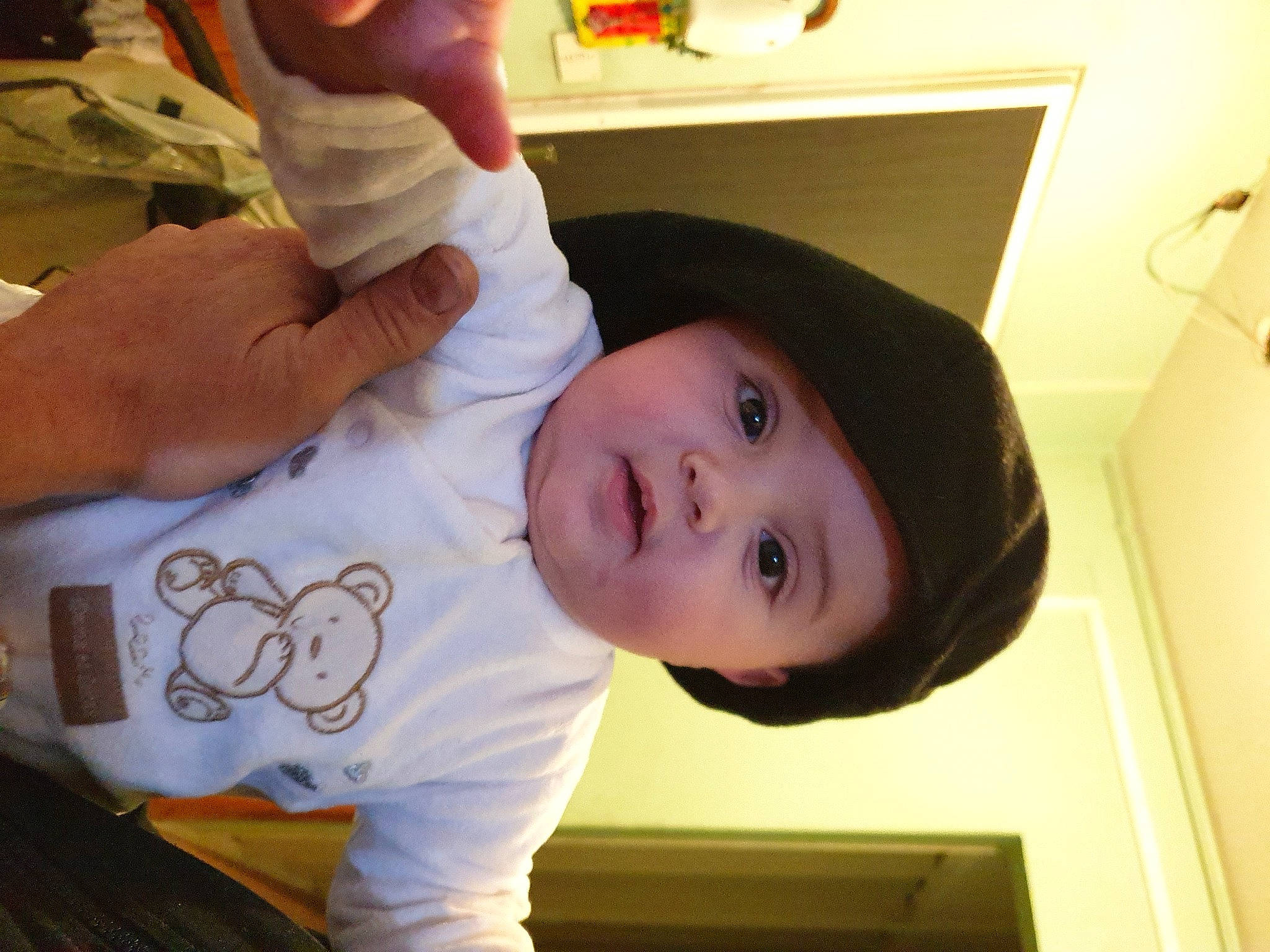 Lyam participe au concours pour gagner de l'argent avec cette photo : abdomen, arm, baby, baby_toddler_clothing, cheek, child, elbow, eyelash, finger, happy, hat, headwear, mouth, nail, nose, person, room, sleeve, smile, t_shirt