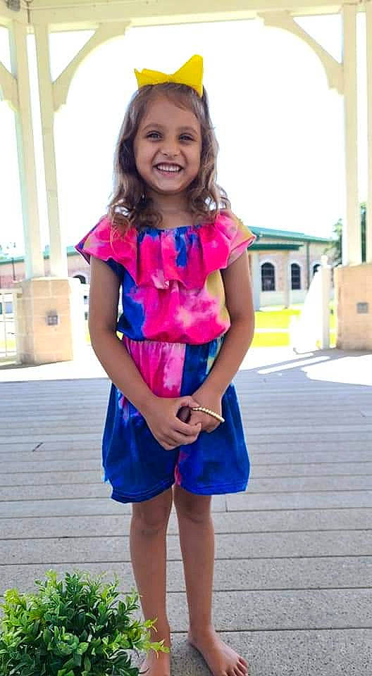 Kingsley is registered to the contest to win money with this photo: clothing, day_dress, dress, electric_blue, face, happy, jewellery, joy, magenta, neck, person, pink, shoulder, sky, sleeve, smile, standing, street_fashion, toddler, travel