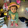 Eliza is registered to the contest to win money with this photo: toddler, child, hat, green_shirt, cheetah_print, indoor, playroom, toy, shopping_cart, slippers, flooring, curious_expression, person, footwear, wooden_floor, basket, stuffed_toy, colorful, standing, looking_up