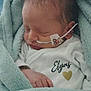 newborn, baby, infant, blanket, sleeping, medical_tube, teddy_bear_sticker, onesie, name_printed, heart_symbol, soft_texture, wrapped, peaceful, cute, child, portrait, indoors, closeup, face, hand