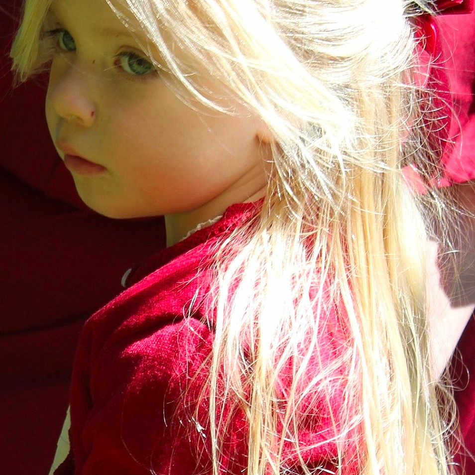 Iris participe au concours pour gagner de l'argent avec cette photo : blonde_hair, casual, child, childhood, close_up, cute, face, fashion, hair_clip, indoor, long_hair, natural_light, pensive, person, portrait, red_sweater, side_view, sitting, soft_light, young_girl