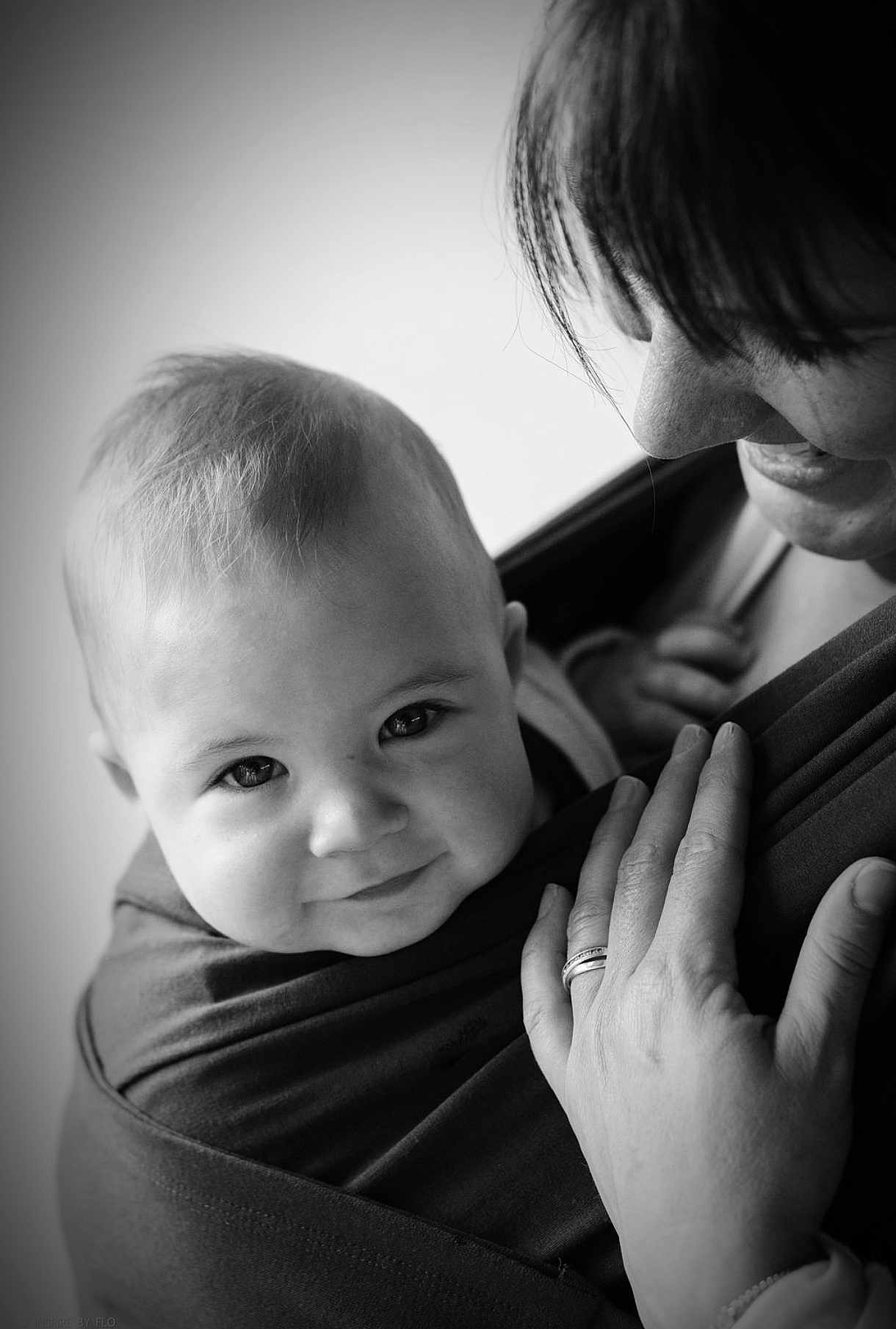 Lou participe au concours pour gagner de l'argent avec cette photo : baby, child, smiling, black_and_white, portrait, close_up, face, person, adult, hand, ring, hair, hug, love, bond, babywearing, fabric, skin, parent, affection