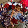baby, child, smiling, headband, flowers, red_star, patriotic, decoration, blue_tutu, wooden_floor, outdoor, happy, cute, person, sitting, festive, red, white, blue, celebration