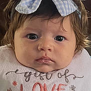 Avaiya is registered to the contest to win money with this photo: baby, child, headband, bow, bib, love, face, portrait, indoor, curly_hair, blue, ball, clothing, cute, young, expression, person, infant, sitting, closeup