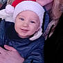 adult, baby, child, closeup, cozy, curly_hair, face, family, festive, hand, happy, holiday, indoor, jacket, person, portrait, santa_hat, smile, warm, winter_clothing