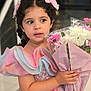 child, girl, flower_bouquet, pastel_colors, dress, ruffles, braided_hair, pink_bow, indoor, portrait, cute, curious, holding, flowers, celebration, smiling, young, pretty, fashion, happy