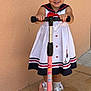 Jamilah joined the competition — help win amazing prizes! child, girl, smiling, pigtails, red_ribbons, white_dress, sailor_style, scooter, pink_scooter, outdoor, sidewalk, wall, sunlight, white_shoes, socks, happy, cute, playful, standing, portrait