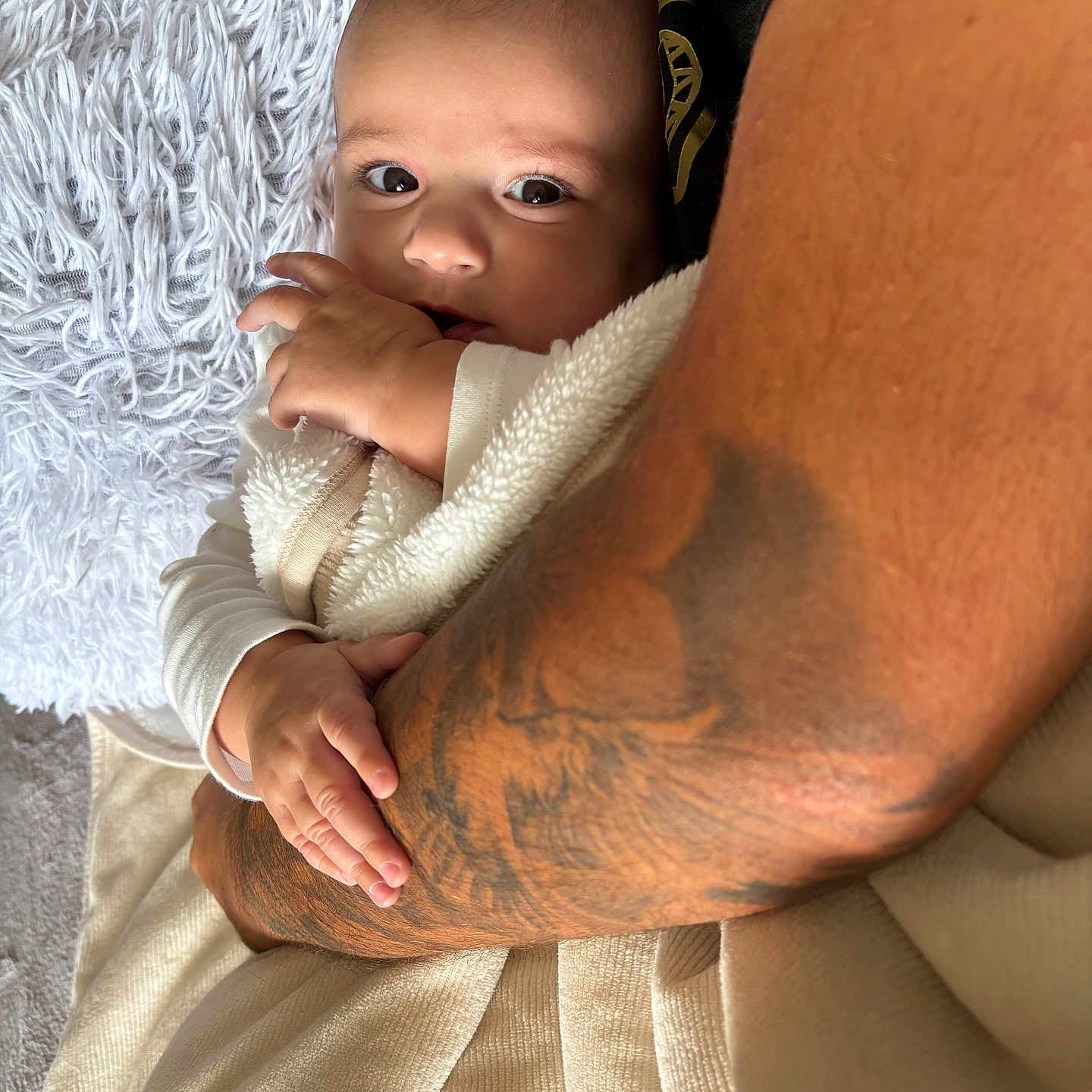 Ezio a rejoint le concours — aidez-le/la à gagner de superbes lots ! arm, baby, blanket, care, closeup, clothing, comfort, cuddle, family, hand, indoor, infant, love, person, portrait, rest, skin, soft, tattoo, warmth
