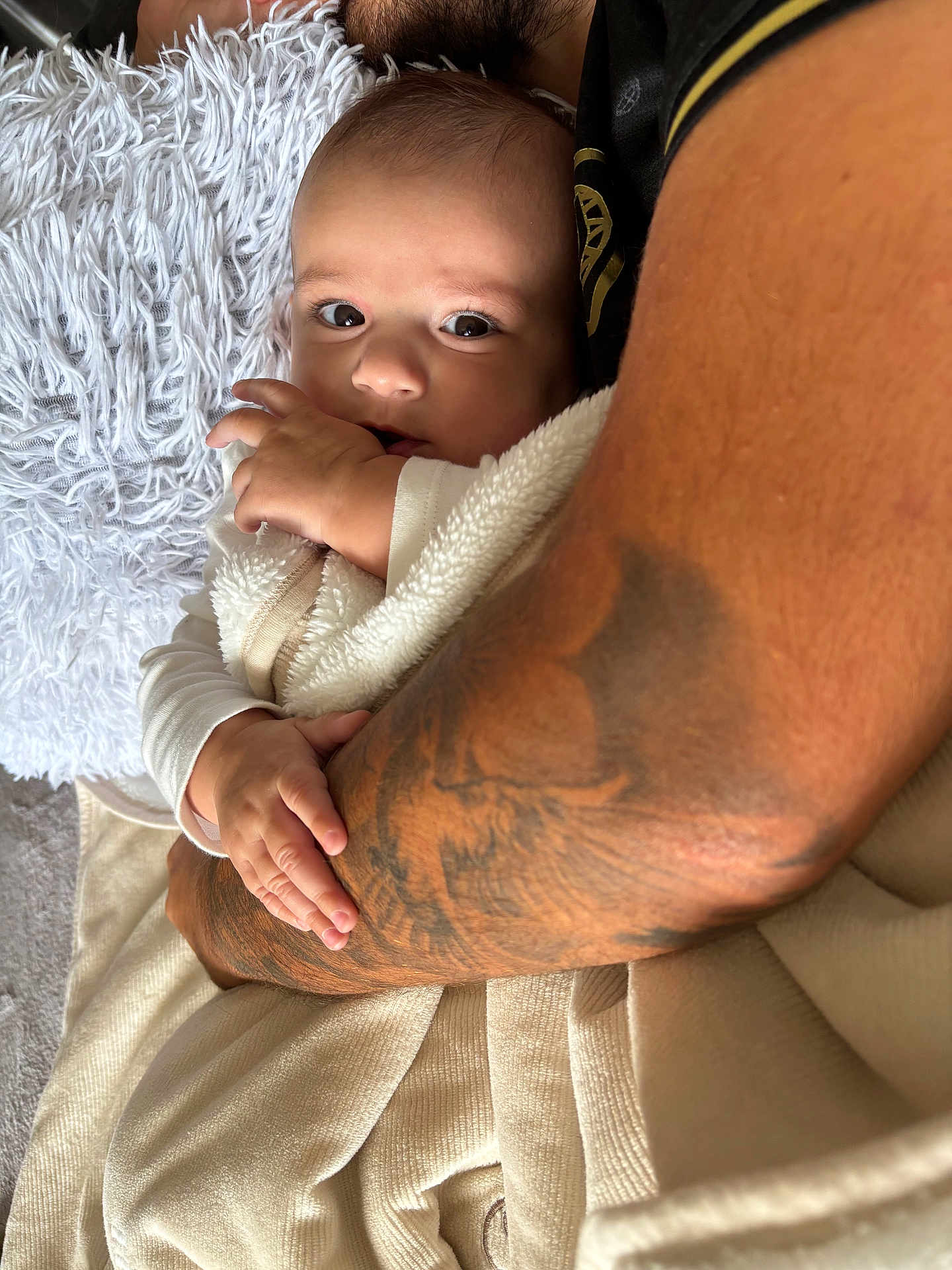 Ezio a rejoint le concours — aidez-le/la à gagner de superbes lots ! baby, infant, person, arm, tattoo, blanket, hand, skin, clothing, cuddle, comfort, indoor, closeup, portrait, soft, warmth, rest, care, family, love