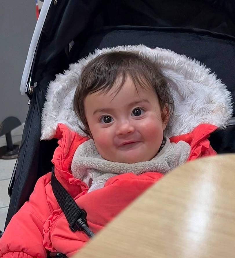 Cylia participe au concours pour gagner de l'argent avec cette photo : baby, baby_carriage, baby_products, baby_safety, baby_toddler_clothing, cheek, child, comfort, eyebrow, fashion_accessory, freezing, fun, happy, person, sitting, skin, sleeve, smile, toddler, winter