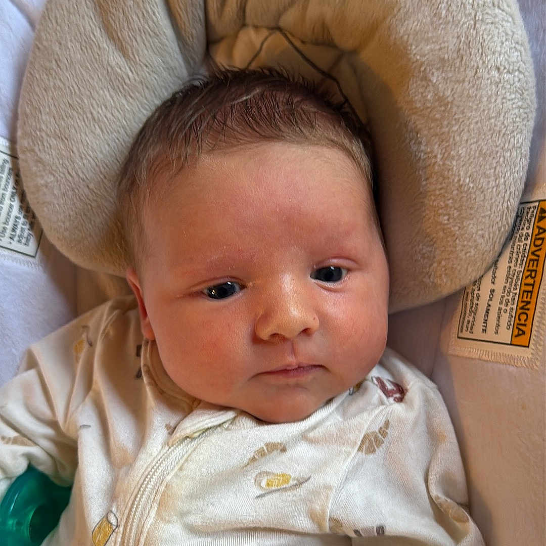 Chance is registered to the contest to win money with this photo: baby, baby_bedding, blanket, child, comfort, cute, face, head_support, human, indoors, infant, lying_down, newborn, pajamas, person, portrait, resting, skin, sleeping_bag, soft