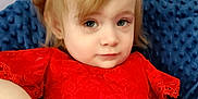 Mary is registered to the contest to win money with this photo: toddler, child, blonde_hair, red_dress, headband, blue_cushion, portrait, indoors, cute, young_child, fashion, lace, sitting, relaxed, person, face, skin, hand, expression, casual
