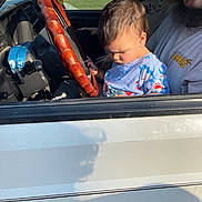 Luxton joined the competition — help win amazing prizes! child, toddler, adult, beard, steering_wheel, truck, vehicle_interior, window, seat, shirt, outdoor, daylight, house, grass, hand, face, person, curious, casual_clothing, family