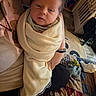 newborn, baby, infant, child, portrait, face, eyes, hair, swaddled, blanket, cream_blanket, held, adult_hands, bed, bedding, plaid, pillow, indoor, cozy, home