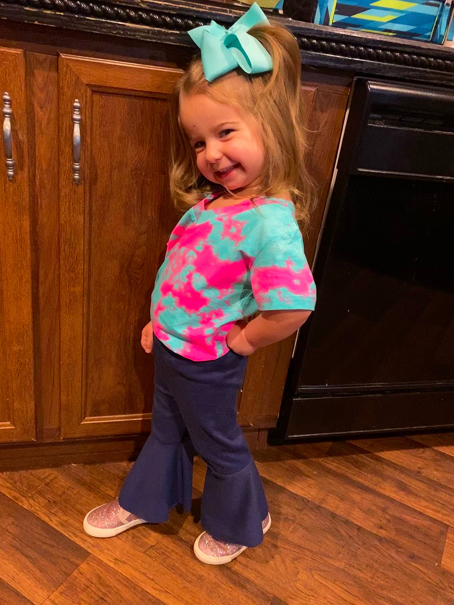 Laney is registered to the contest to win money with this photo: baby_toddler_clothing, child, floor, fun, hardwood, joy, person, pink, play, standing, t_shirt, toddler, turquoise, wood