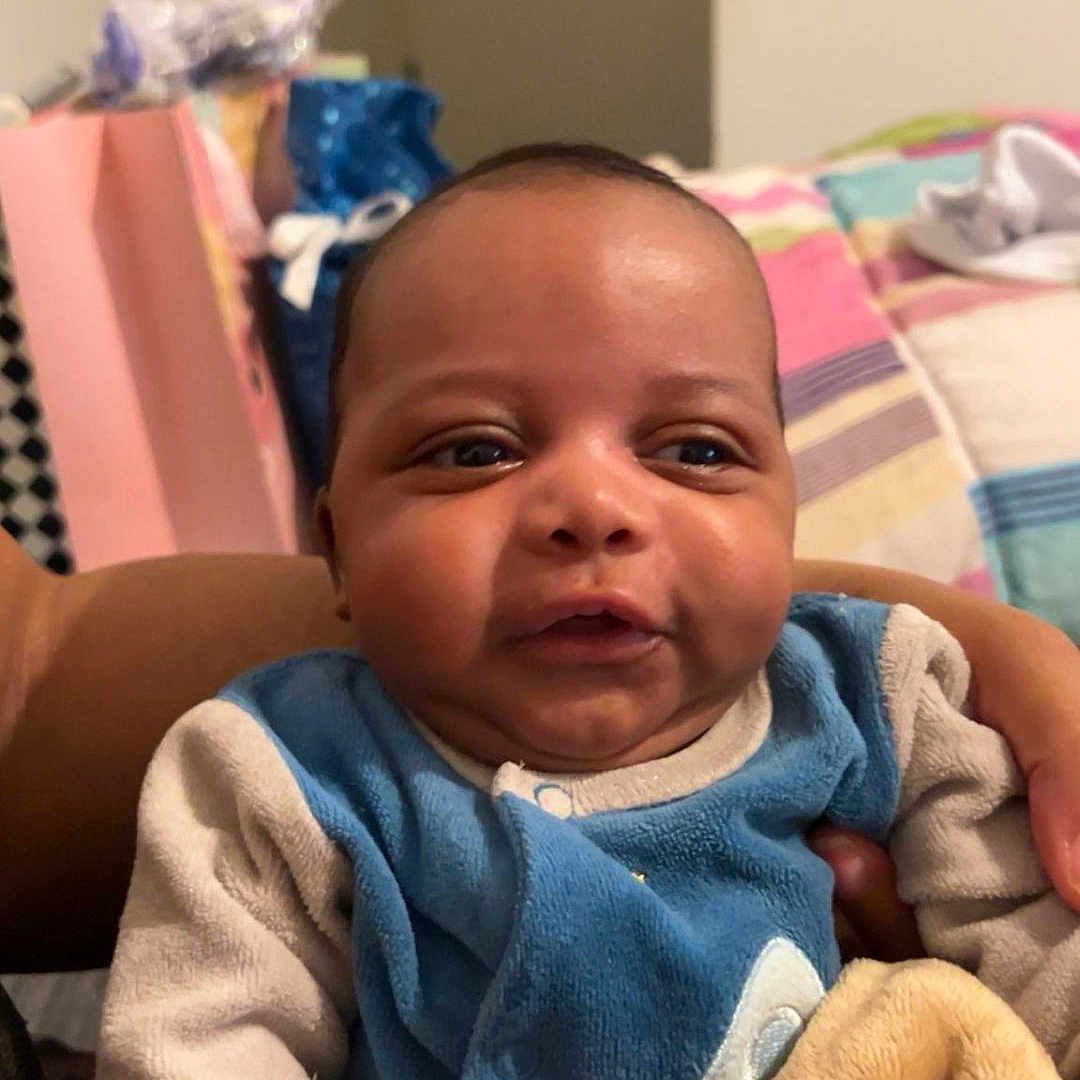 Layann participe au concours pour gagner de l'argent avec cette photo : baby, bedspread, blanket, child, clothing, cozy, cute, expression, face, furniture, hand, head, holding, indoor, infant, person, portrait, skin, smiling, young