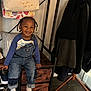 Kydorris joined the competition — help win amazing prizes! child, toddler, smiling, denim_overalls, blue_shirt, braided_hair, bench, drawer, home_interior, coats, clothing, socks, wooden_floor, rug, happy, face, person, furniture, indoor, casual