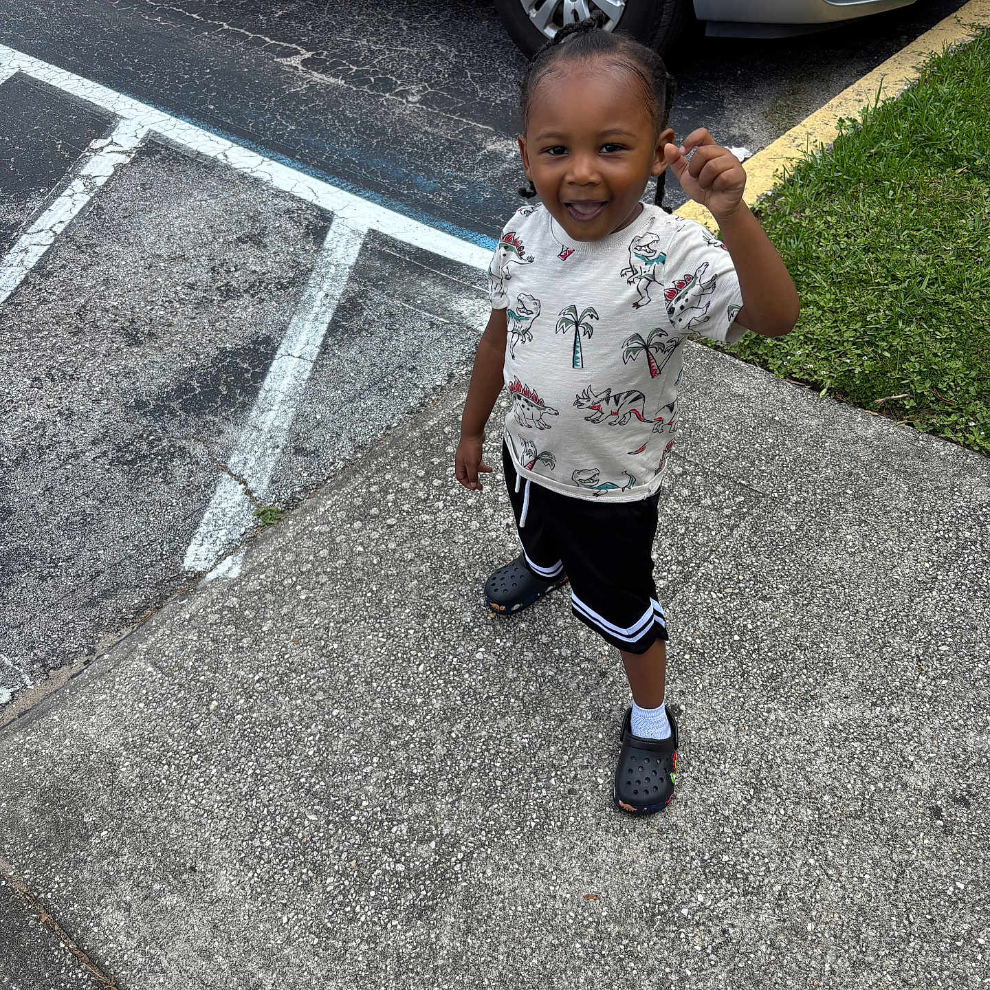 Kydorris joined the competition — help win amazing prizes! asphalt, car, casual_clothing, child, crocs, curb, dinosaur_print, grass, hair_braids, happy, outdoor, parking_lot, shirt, shorts, sidewalk, smiling, standing, summer, toddler, white_socks