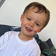 Malone a rejoint le concours — aidez-le/la à gagner de superbes lots ! child, boy, smiling, tshirt, white_clothing, face, hair, indoors, couch, cushion, pattern, leafy, messy, happy, portrait, young_child, casual, home, playful, scrapes