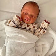 Raphaël participe au concours pour gagner de l'argent avec cette photo : newborn, baby, sleeping, blanket, onesie, patterned_clothing, bear_pattern, star_pattern, white_blanket, cozy, infant, peaceful, soft_texture, wrapped, hand, face, portrait, sleep, cute, bed