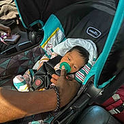 Mulaii joined the competition — help win amazing prizes! baby, car_seat, pacifier, hand, infant, child, seatbelt, car_interior, person, clothing, striped_blanket, safety, restraint, transportation, window, sunlight, fabric, seat, adult_hand, bracelet