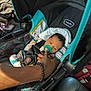 baby, car_seat, pacifier, hand, infant, child, seatbelt, car_interior, person, clothing, striped_blanket, safety, restraint, transportation, window, sunlight, fabric, seat, adult_hand, bracelet