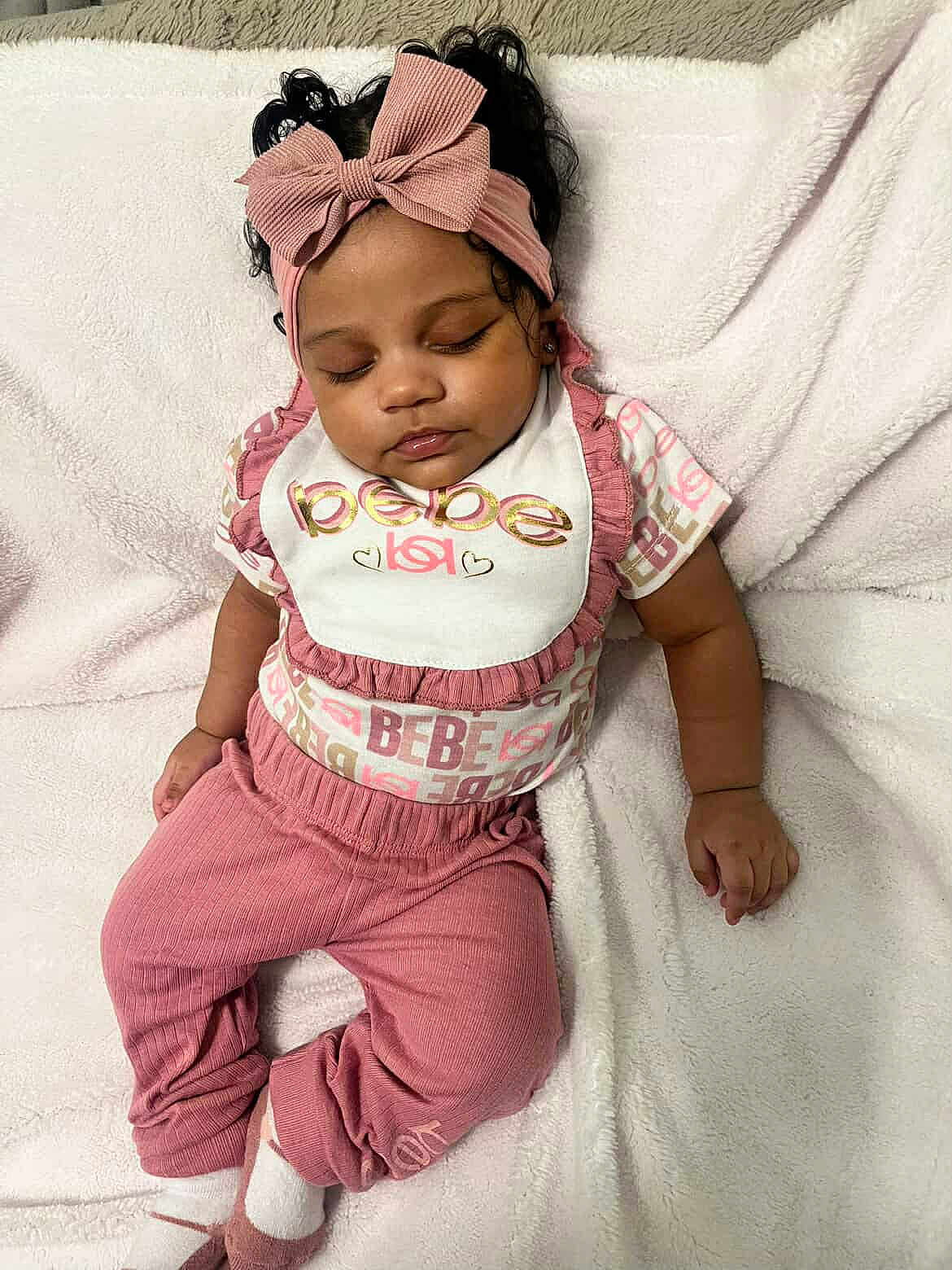 Mulaina is registered to the contest to win money with this photo: baby, sleeping, headband, bow, pink_clothing, white_blanket, infant, cute, peaceful, toddler, soft_texture, child, portrait, resting, cozy, fashion, smiling_face, indoor, young_child, relaxed