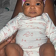Trinity is registered to the contest to win money with this photo: baby, infant, child, pink_bow, headband, onesie, bird_pattern, legs, feet, socks, hand, lap, skin, portrait, indoors, cute, expression, looking_at_camera, person, clothing